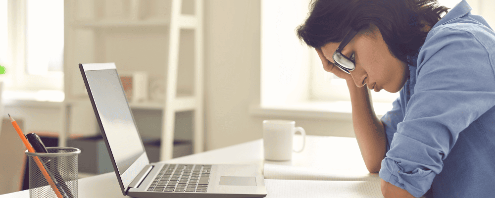 Social Recruiting Mentoirng bei Socialmed - Online Recruiting. Junge Frau mit dunkler Hautfarbe sitzt ratlos vorm Laptop